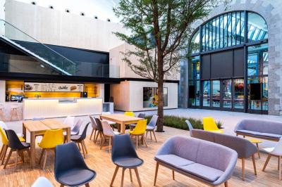 Façade d'un cinéma avec deux grandes portes vitrées, affiches de films et architecture en pierre apparente.