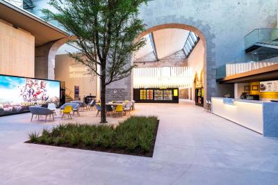Façade d'un cinéma avec deux grandes portes vitrées, affiches de films et architecture en pierre apparente.