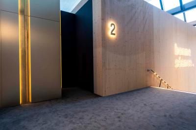 Façade d'un cinéma avec deux grandes portes vitrées, affiches de films et architecture en pierre apparente.