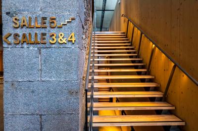 Façade d'un cinéma avec deux grandes portes vitrées, affiches de films et architecture en pierre apparente.