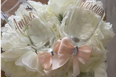 Miniature Miss Majestic #12 Flûte personnalisée avec le prénom ’Marion’ et bougie marquée ’50 ans’, posées sur une table devant un fond rose.