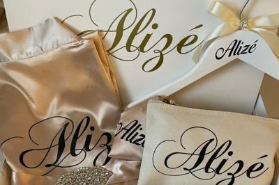 Miniature Miss Majestic #6 Flûte personnalisée avec le prénom ’Marion’ et bougie marquée ’50 ans’, posées sur une table devant un fond rose.