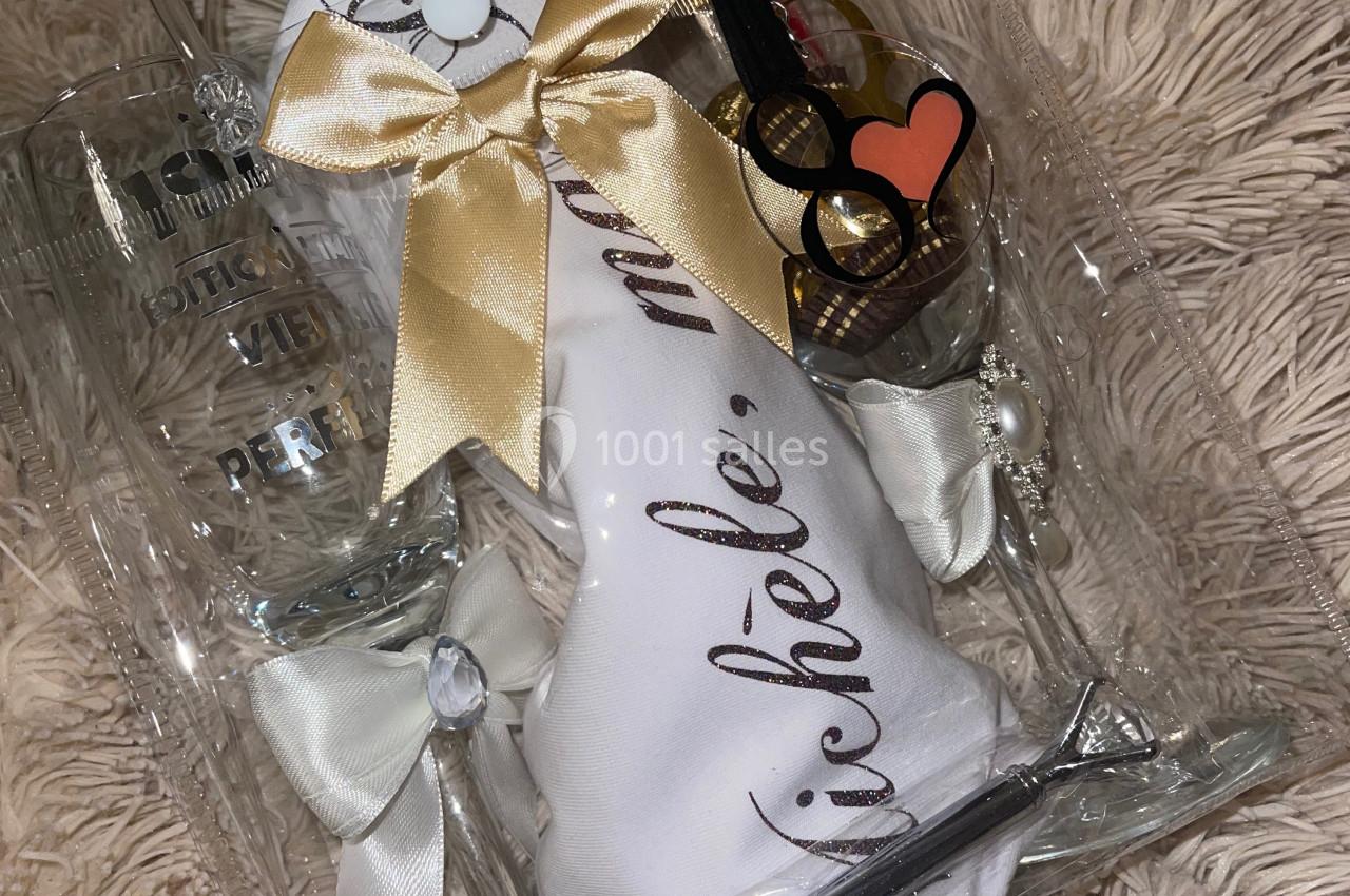 Ensemble cadeau comprenant des verres, un tissu personnalisé et des accessoires, présenté sur un fond en tissu beige.