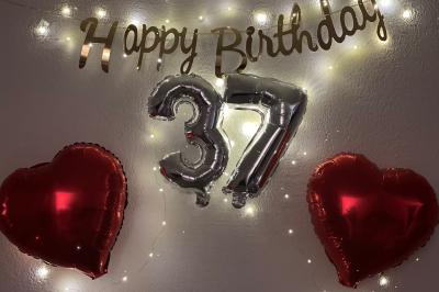 Miniature Miss Majestic #27 Flûte personnalisée avec le prénom ’Marion’ et bougie marquée ’50 ans’, posées sur une table devant un fond rose.