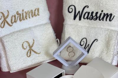 Miniature Miss Majestic #30 Flûte personnalisée avec le prénom ’Marion’ et bougie marquée ’50 ans’, posées sur une table devant un fond rose.