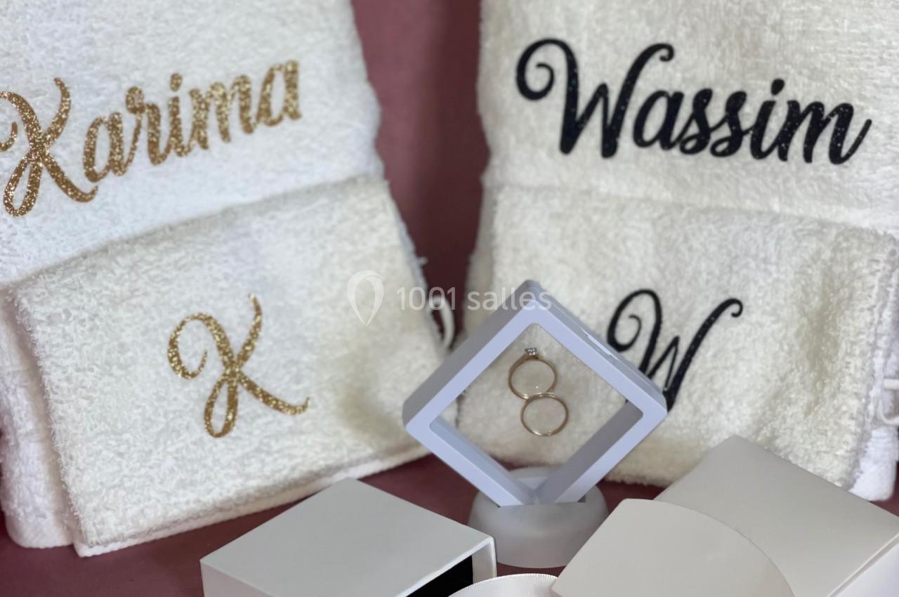 Serviettes blanches personnalisées avec des prénoms et initiales, accompagnées d'une boîte et d'un présentoir à bijoux.