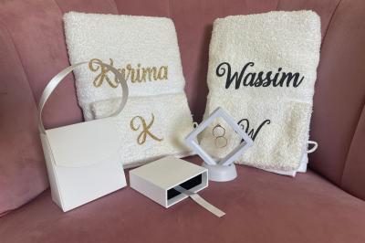 Miniature Miss Majestic #31 Flûte personnalisée avec le prénom ’Marion’ et bougie marquée ’50 ans’, posées sur une table devant un fond rose.