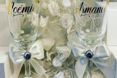 Miniature Miss Majestic #35 Flûte personnalisée avec le prénom ’Marion’ et bougie marquée ’50 ans’, posées sur une table devant un fond rose.