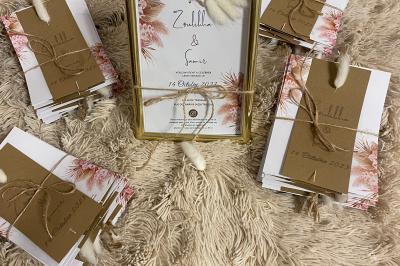 Miniature Miss Majestic #36 Flûte personnalisée avec le prénom ’Marion’ et bougie marquée ’50 ans’, posées sur une table devant un fond rose.