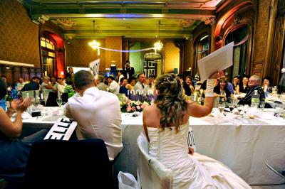 Un homme en costume utilise une table de mixage lors d'un événement en extérieur, avec des ballons en arrière-plan.