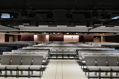 Miniature Location salle Croissy-Beaubourg (Seine-et-Marne) - La Mega Place #14 Vue aérienne d'un grand bâtiment moderne avec un parking rempli de voitures à l'avant et des arbres en arrière-plan.