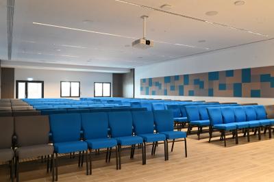 Miniature Location salle Croissy-Beaubourg (Seine-et-Marne) - La Mega Place #18 Vue aérienne d'un grand bâtiment moderne avec un parking rempli de voitures à l'avant et des arbres en arrière-plan.