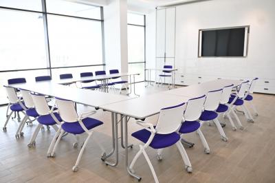 Miniature Location salle Croissy-Beaubourg (Seine-et-Marne) - La Mega Place #26 Vue aérienne d'un grand bâtiment moderne avec un parking rempli de voitures à l'avant et des arbres en arrière-plan.