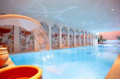 Lit double avec coussins décoratifs, éclairage mural en néon en forme de visage et lampes suspendues avec abat-jour en…