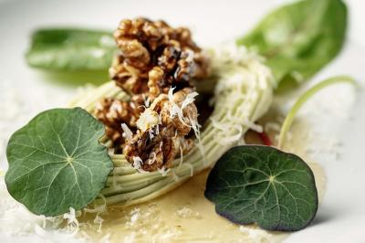 Dessert composé de fraises fraîches, sorbet, crème chantilly et petites feuilles de basilic dans une assiette blanche.