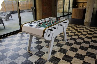Salle de réunion moderne avec table noire, chaises, écran mural, tableau blanc et éclairage encastré.