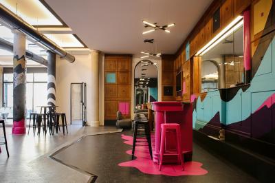 Salle de réunion moderne avec table noire, chaises, écran mural, tableau blanc et éclairage encastré.