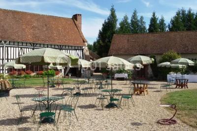 Salle de réception décorée avec des tables rondes dressées, des lanternes suspendues et un éclairage tamisé.