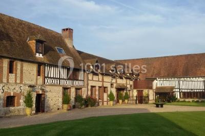 Salle de réception décorée avec des tables rondes dressées, des lanternes suspendues et un éclairage tamisé.