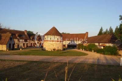 Salle de réception décorée avec des tables rondes dressées, des lanternes suspendues et un éclairage tamisé.