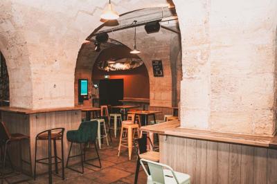 Cabine photo vintage avec rideaux rouges, entourée de tabourets empilés et d'un distributeur automatique rouge.