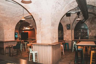 Cabine photo vintage avec rideaux rouges, entourée de tabourets empilés et d'un distributeur automatique rouge.