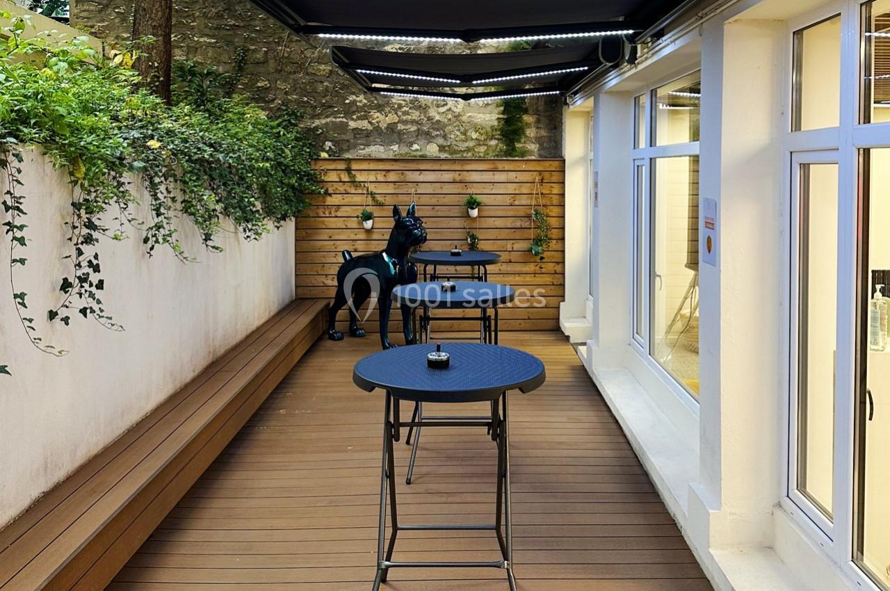 La terrasse avec mange debout, cendriers, et stores éclairés