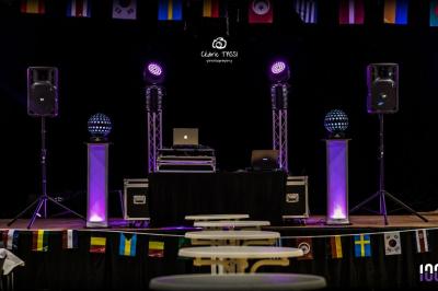 Foule dansant sous des jeux de lumière colorés lors d'une soirée festive en intérieur.