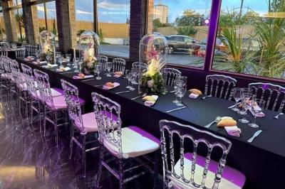 Salle de bain avec lavabo en pierre, trois miroirs dorés rectangulaires et murs en marbre aux motifs noirs et blancs.