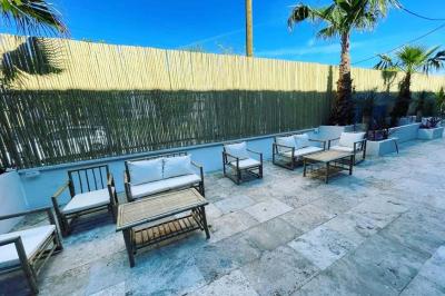 Salle de bain avec lavabo en pierre, trois miroirs dorés rectangulaires et murs en marbre aux motifs noirs et blancs.