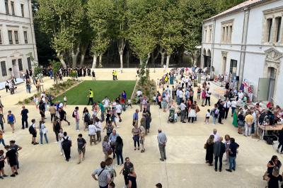 Miniature Location salle Beaucaire (Gard) - Domaine de Saint Félix #7 Cour intérieure avec des plantes, une statue en premier plan et un groupe de personnes rassemblées près d'un bâtiment ancien.