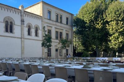 Miniature Location salle Beaucaire (Gard) - Domaine de Saint Félix #8 Cour intérieure avec des plantes, une statue en premier plan et un groupe de personnes rassemblées près d'un bâtiment ancien.