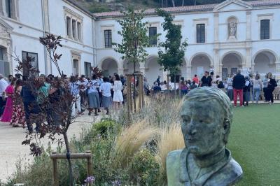 Miniature Location salle Beaucaire (Gard) - Domaine de Saint Félix #9 Cour intérieure avec des plantes, une statue en premier plan et un groupe de personnes rassemblées près d'un bâtiment ancien.