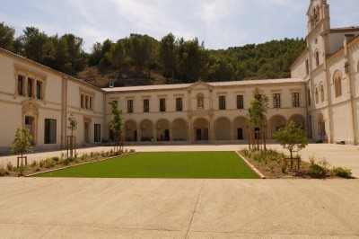 Miniature Location salle Beaucaire (Gard) - Domaine de Saint Félix #4 Façade d'un bâtiment historique blanc avec une cour aménagée de pelouse, d'arbustes et d'arbres jeunes.