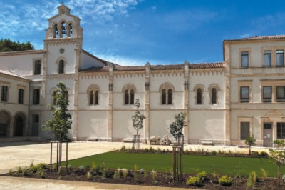 Miniature Location salle Beaucaire (Gard) - Domaine de Saint Félix #31 Façade d'un bâtiment historique blanc avec une cour aménagée de pelouse, d'arbustes et d'arbres jeunes.