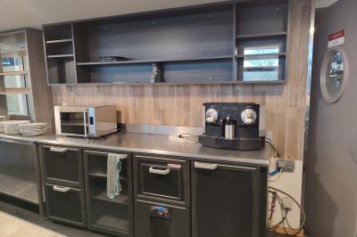 Parking vide en plein air entouré d'arbres, avec un panneau indiquant une zone de stationnement.