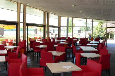 Parking vide en plein air entouré d'arbres, avec un panneau indiquant une zone de stationnement.