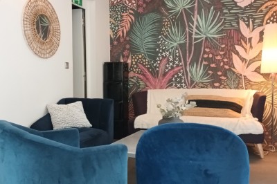 Table décorée avec des fleurs orange, jaunes et bleues, entourant des verres en cristal, dans un cadre élégant.