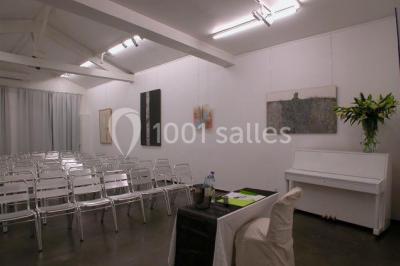 Cuisine moderne avec meubles laqués gris, plan de travail clair, micro-ondes et éclairage intégré.