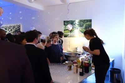 Cuisine moderne avec meubles laqués gris, plan de travail clair, micro-ondes et éclairage intégré.