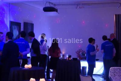 Cuisine moderne avec meubles laqués gris, plan de travail clair, micro-ondes et éclairage intégré.