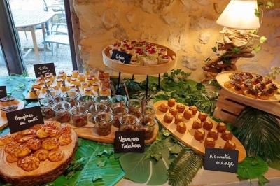 Lit avec serviettes roulées dans une chambre aux murs en pierre apparente et fenêtre laissant entrer la lumière naturelle.