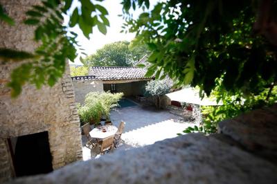 Lit avec serviettes roulées dans une chambre aux murs en pierre apparente et fenêtre laissant entrer la lumière naturelle.