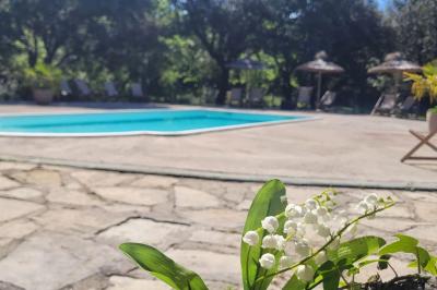 Lit avec serviettes roulées dans une chambre aux murs en pierre apparente et fenêtre laissant entrer la lumière naturelle.