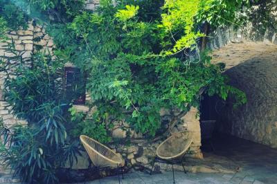 Lit avec serviettes roulées dans une chambre aux murs en pierre apparente et fenêtre laissant entrer la lumière naturelle.
