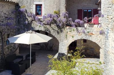 Lit avec serviettes roulées dans une chambre aux murs en pierre apparente et fenêtre laissant entrer la lumière naturelle.