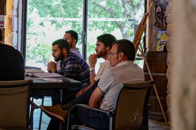 Lit avec serviettes roulées dans une chambre aux murs en pierre apparente et fenêtre laissant entrer la lumière naturelle.