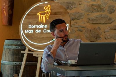 Lit avec serviettes roulées dans une chambre aux murs en pierre apparente et fenêtre laissant entrer la lumière naturelle.