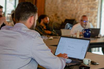 Lit avec serviettes roulées dans une chambre aux murs en pierre apparente et fenêtre laissant entrer la lumière naturelle.