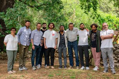 Lit avec serviettes roulées dans une chambre aux murs en pierre apparente et fenêtre laissant entrer la lumière naturelle.